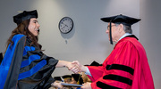 Clinical Psychology graduate Adriana Cabrales, Ph.D., is all smiles as she receives her diploma from Dr. Podolsky.