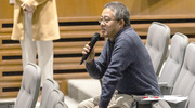 A forum attendee asks a question about one of the faculty member’s presentations.