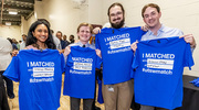 Outfit of the day: the Match Day T-shirt. Holding up their shirts showing their matches, from left, are Riya Albert, Roman Loper, Tyler Bates, and Grant Tucker.