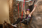 This young player is elated to make it to the top of the rock-climbing wall.