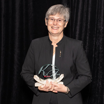 Woman in white lab coat, wearing glasses