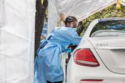 Nurse Octavia Wilson tests a patient at the drive-through COVID-19 testing site outside Bass Center.