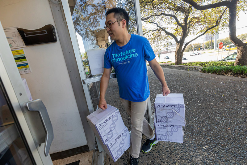 Man walking into buidling carrying boxes