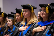 Clinical Psychology students and mentors Drs. Katie Bellone, Julia Cartwright, Caroline Brasch, and Alina Suris, have hands over hearts during the national anthem.