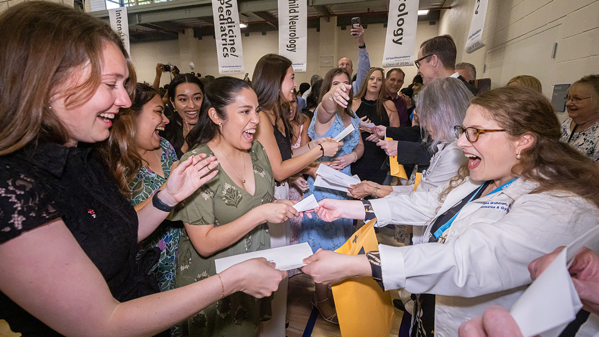 Excited students being handed an envelope.