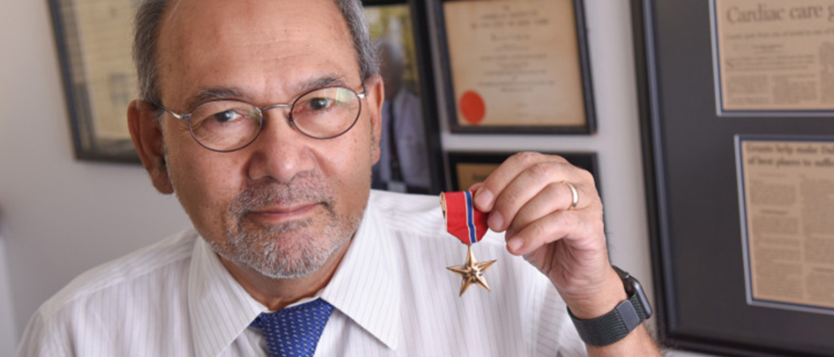 Dr. Ahamed Idris holding his Bronze Star - heading image