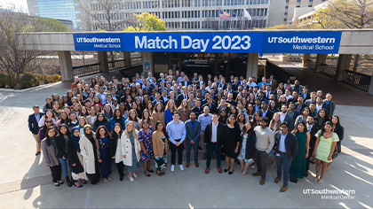 large cluster of students around match day sign