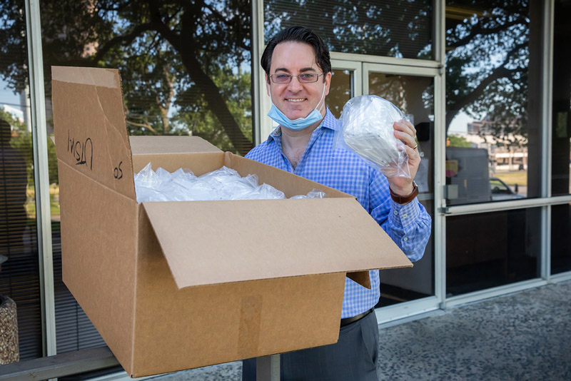 Man smiling holding cardboard box