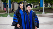 Neuroscience graduate Andrea Boitnott, Ph.D., left, and Cancer Biology graduate Julisa Gonzalez, Ph.D., celebrate their achievements with a photo on the Plaza.