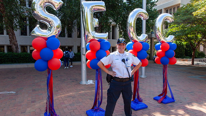 Public safety officer posing in front of balloons in a power stance