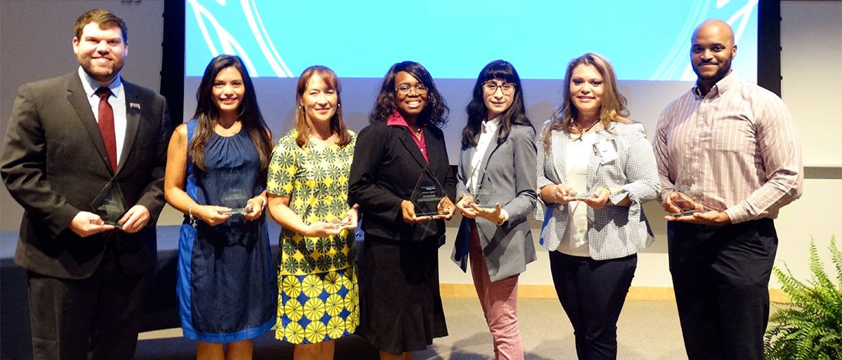 seven people holding awards