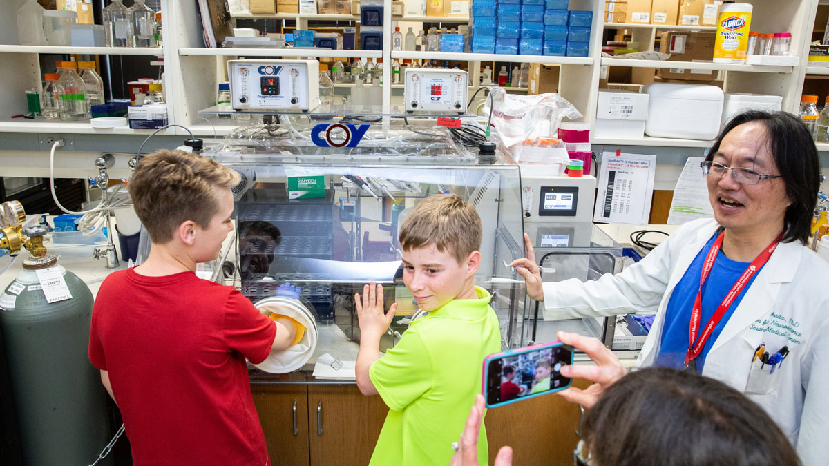 Two young visitors get their hands on some lab equipment.