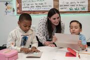 A Biomedical Preparatory teacher helps students decorate cards.