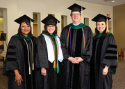 UT Southwestern Medical School Student Affairs Associate Deans Drs. Shawna Nesbitt, Angela Mihalic, Blake Barker, and Melanie Sulistio gather for a photo ahead of the hooding ceremony.