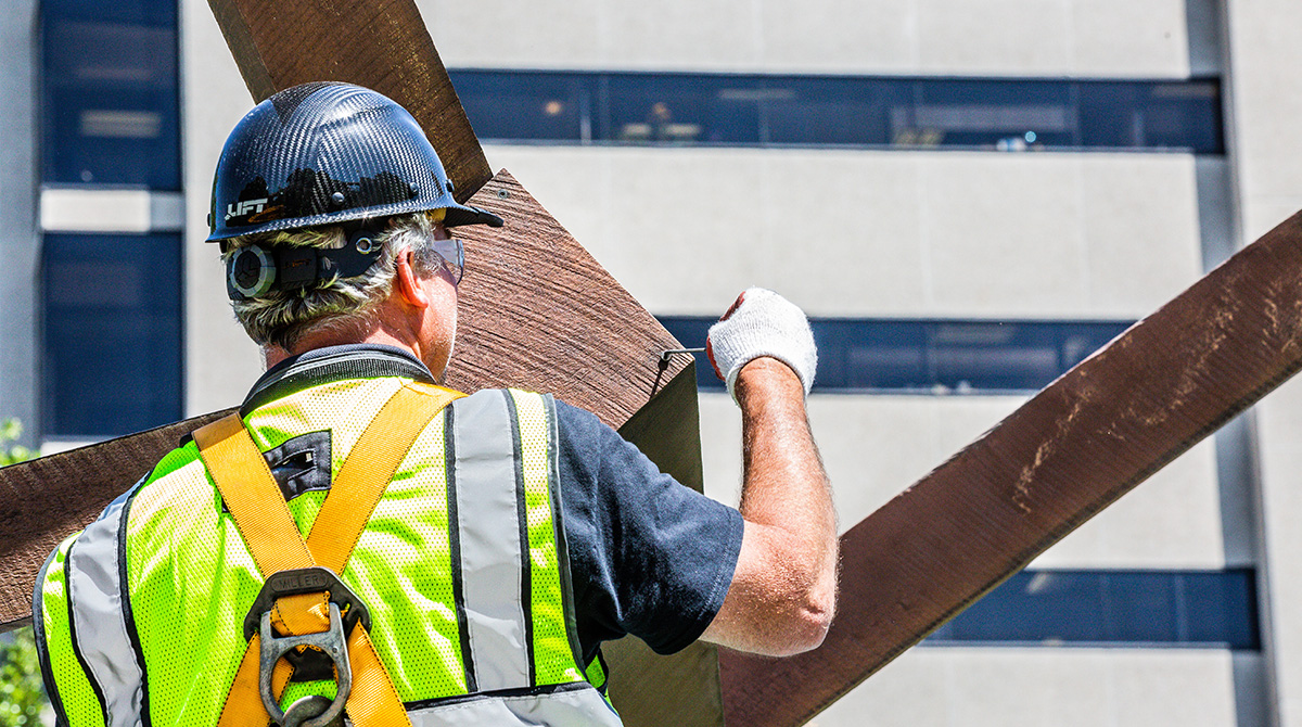 Worker inserting screw into sculpture