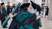 Marium Khan, M.D., shares a celebratory hug with a classmate following the ceremony.