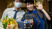 Graduate Wen-Chuan Hsieh (right) shares by phone her accomplishments with family.