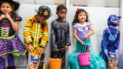 All in a row are five trick-or-treaters showing off their hauls.