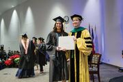 Physician Assistant Studies graduate Adriana De La Rue receives her diploma from Dr. Lee.