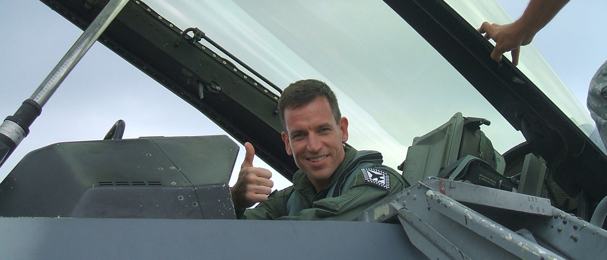 Dr. Vanderveldt in uniform, giving a thumbs-up sign in an F16 aircraft