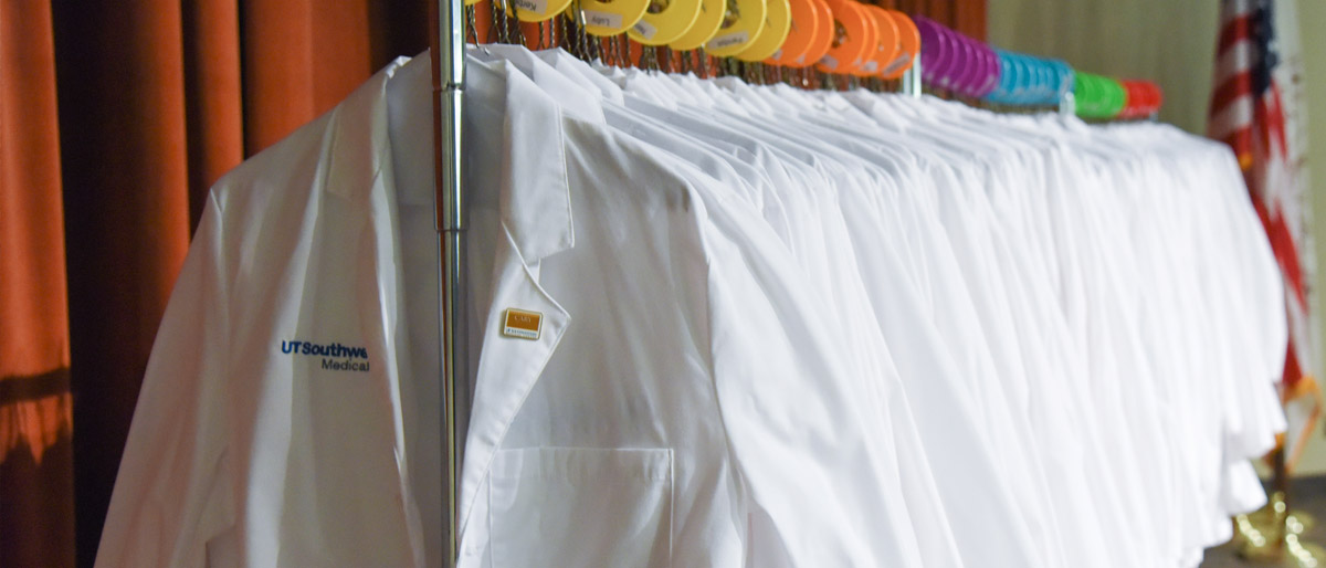 Row of white coats on a rack