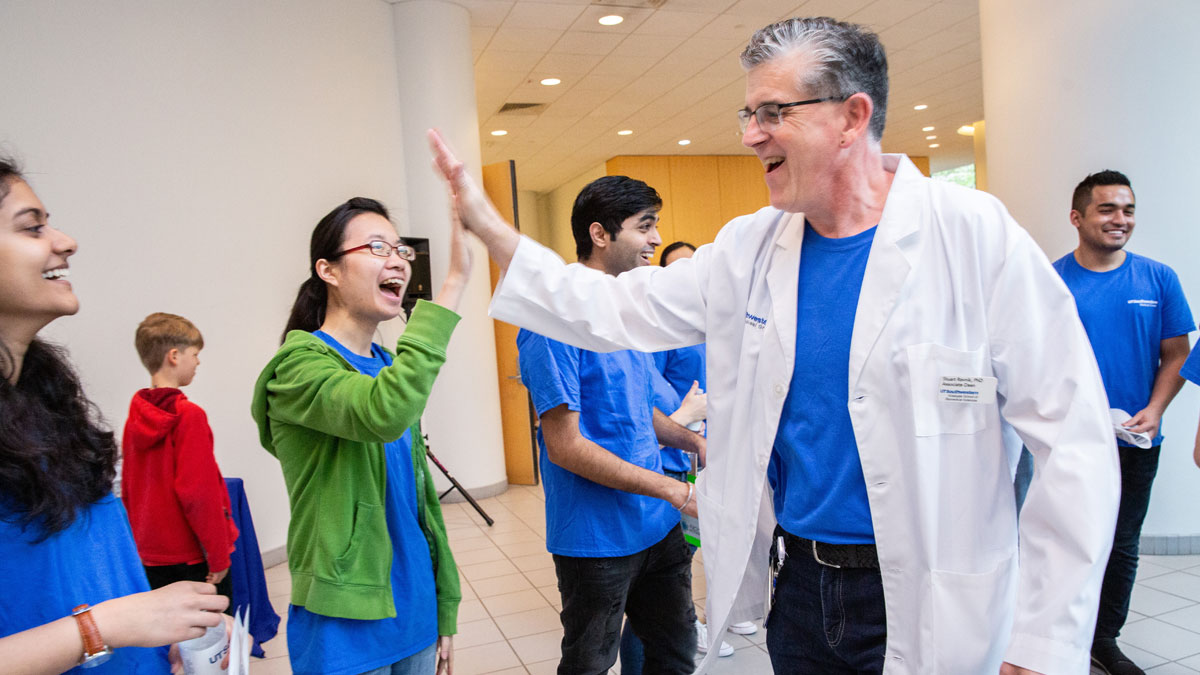 Dr. Stuart Ravnik (right) high-fives a volunteer.