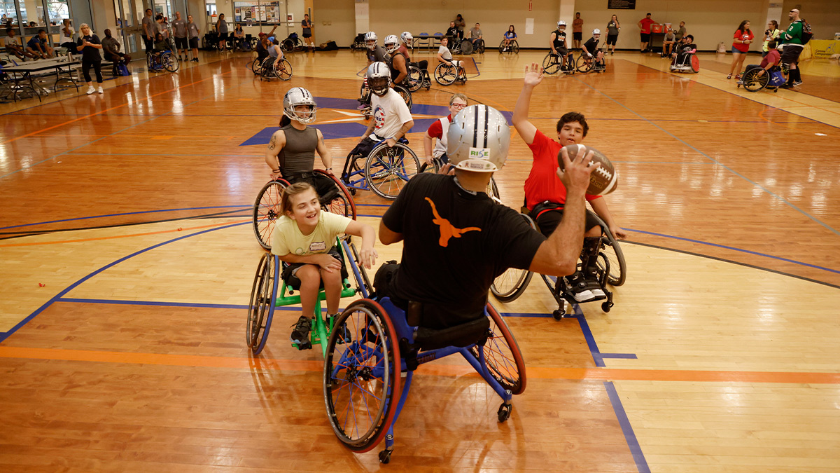 participants in wheelchairs play game with ball