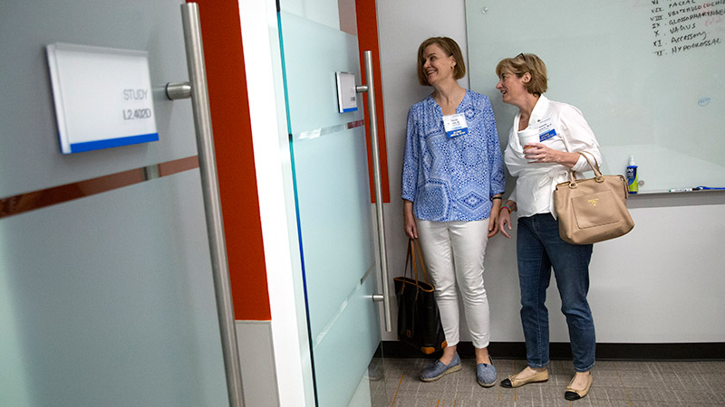 Two women peeking into a classroom