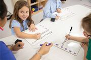 Students practice writing their letters.