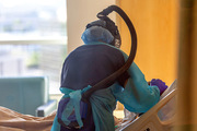 A nurse treats a patient in a ward designated for COVID-19 patients.