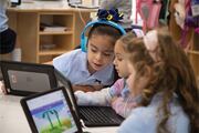 Three girls discuss the interactive computer lesson.