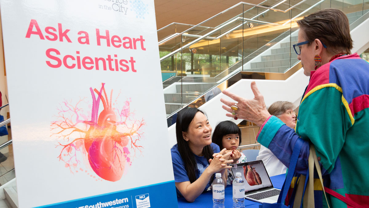 A volunteer interacts with visitors at the "Ask a Heart Scientist" table.