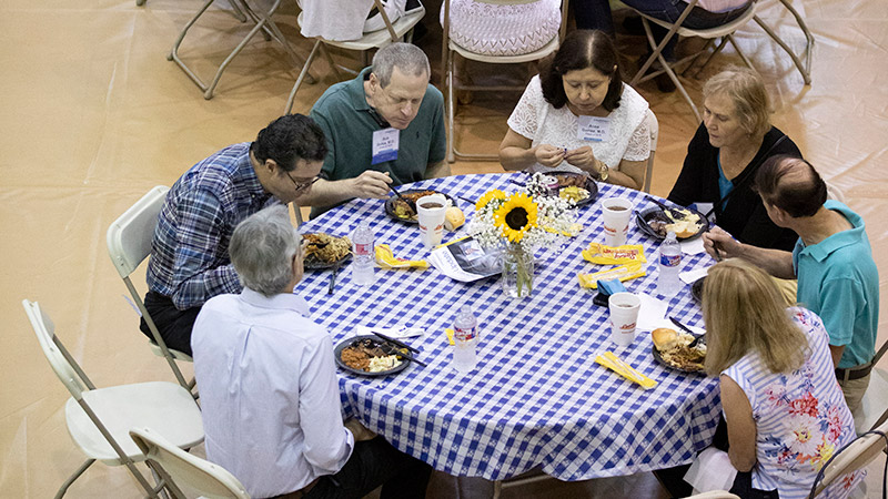 People gathered around a table, eating food.