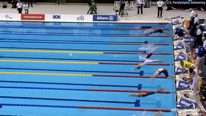 Athletes diving into a swiming pool divided by lanes