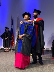 Dr. Mike Henne, Assistant Professor of Cell Biology and Biophysics, hoods Dr. Sanchari Datta, who earned her doctorate in cell and molecular biology.