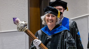 Jane Johnson, Ph.D., Professor of Neuroscience and Pharmacology, carries the Stembridge Mace as she enters the auditorium. The symbol represents the torch of learning and passing of knowledge from teacher to student over generations.