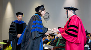 Biomedical Engineering graduate Hui-Ju Wang, Ph.D., shakes Dr. Podolsky’s hand as she receives her diploma.