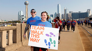 Two walkers hold a festive sign that says “Team: Walk This Way.”