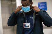 Clinic Staff Coordinator Steffon Mckinley puts on a mask before entering.