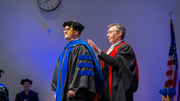 Sean Rogers (left) is hooded by mentor Mike Henne, Ph.D., Associate Professor of Cell Biology and Biophysics.