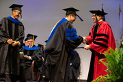 Dr. Zhongxu An (center) receives his diploma from President Dr. Daniel K. Podolsky, as Dr. An’s mentor, Dr. Changho Choi (left) beams with pride.