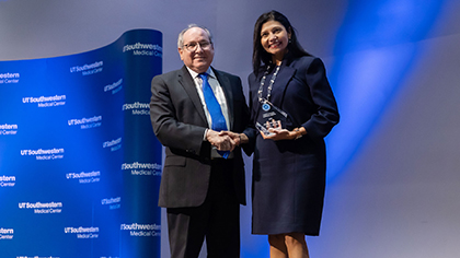 Dr. Podolsky shaking hands with a female winner.