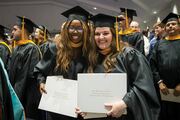 Proudly showing off their diplomas are Physician Assistant Studies graduates Jane Igbeka (left) and Shelby Hunt.