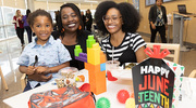 LaTonya Rosales (center), co-chair for African American Employee BRG, enjoys the Juneteenth celebration with her daughter Kianna Rosales (right) and her 3-year-old grandson Carmelo Skinner (left).