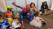 Spiderman is surrounded by happy trick-or-treaters following the parade.