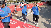 A victorious UTSW walker and her friend lift their hands in celebration upon finishing the walk.