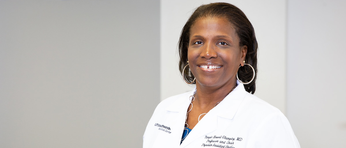 Woman with dark hair, wearing white lab coat