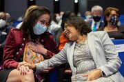 Dr. Sunati Sahoo smiles and embraces Dr. Lina Chalak as she returns from the podium.