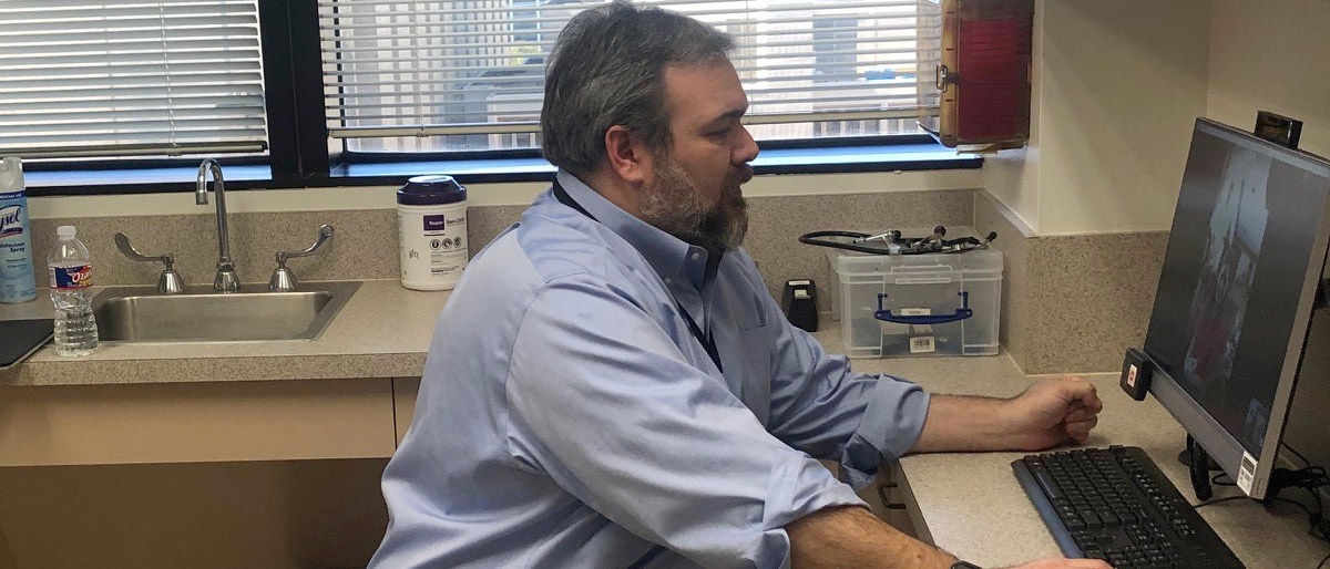 Man sitting at computer with webcam