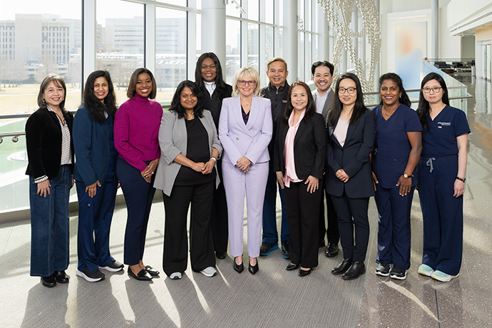 12 nurses gather in front of a large window.